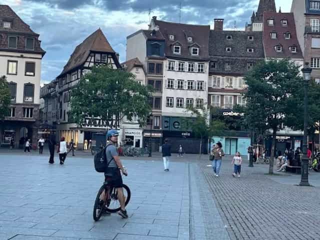 Radfahrer auf dem Place Kléber in Straßburg in der Dämmerung